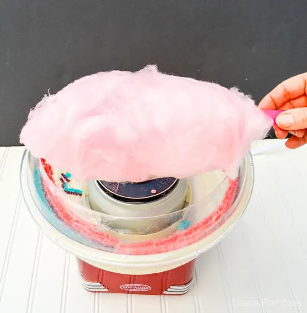 pink cotton candy being made with a cotton candy machine