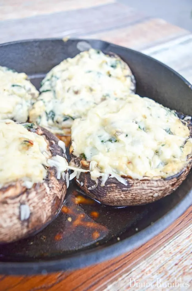 close up of baked Portobello mushrooms with cheese in a cast-iron skillet