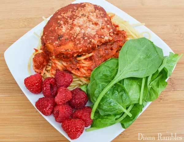 delicious chicken parm dinner on a plate with fruit and a salad