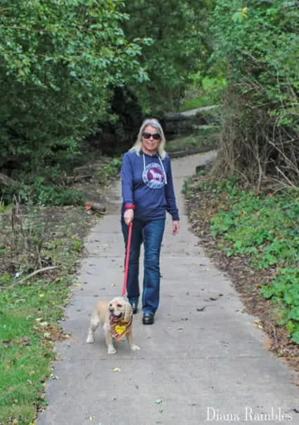 woman walking with a dog on a path in a park