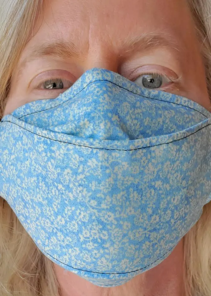 close up of a blue face mask on a woman