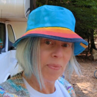 Diana Rambles outside wearing a colorful Aldi hat